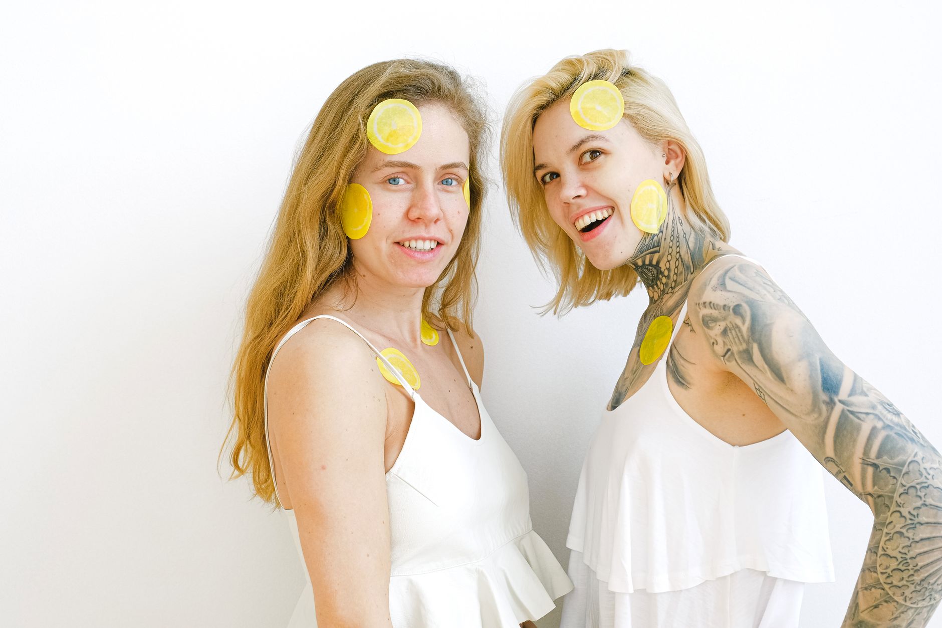 Two women laughing together while enjoying time with lemon slices