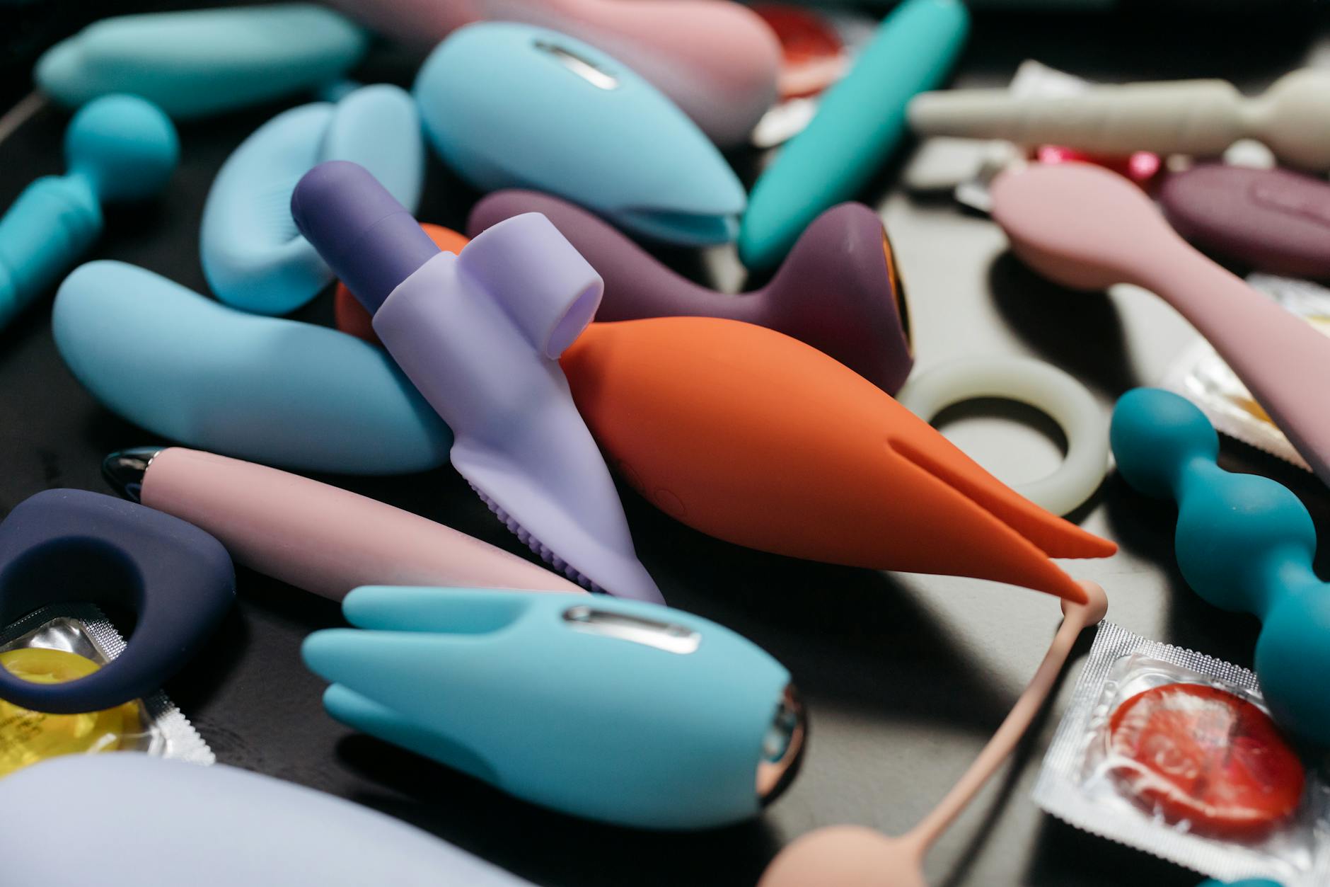 Woman holding colorful vibrators with a confident expression, representing personal pleasure and intimacy
