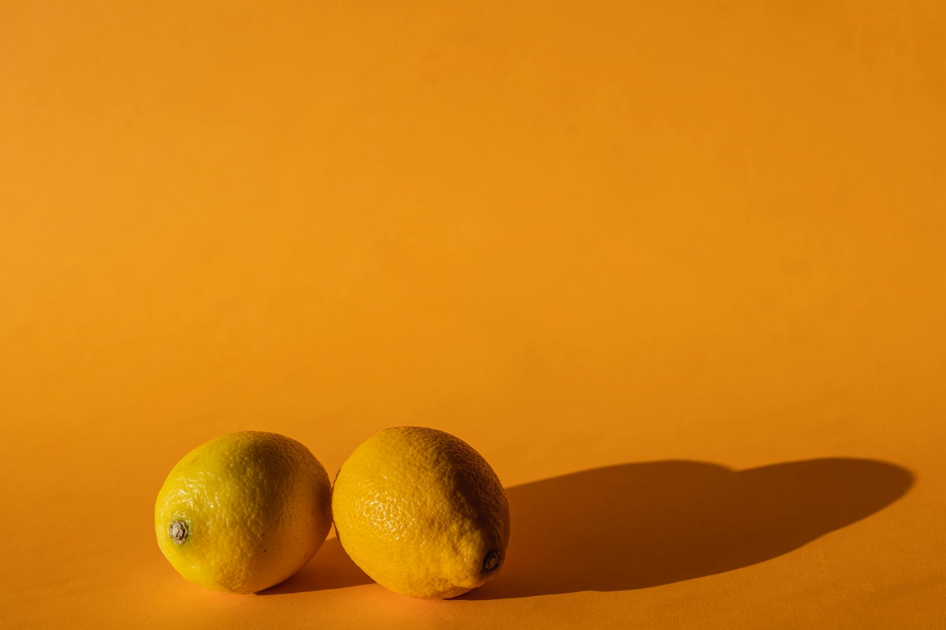 Woman holding fresh lemon at dining table